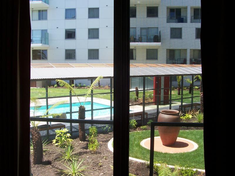 Bedroom 2 view out Balcony window towards central pool area.