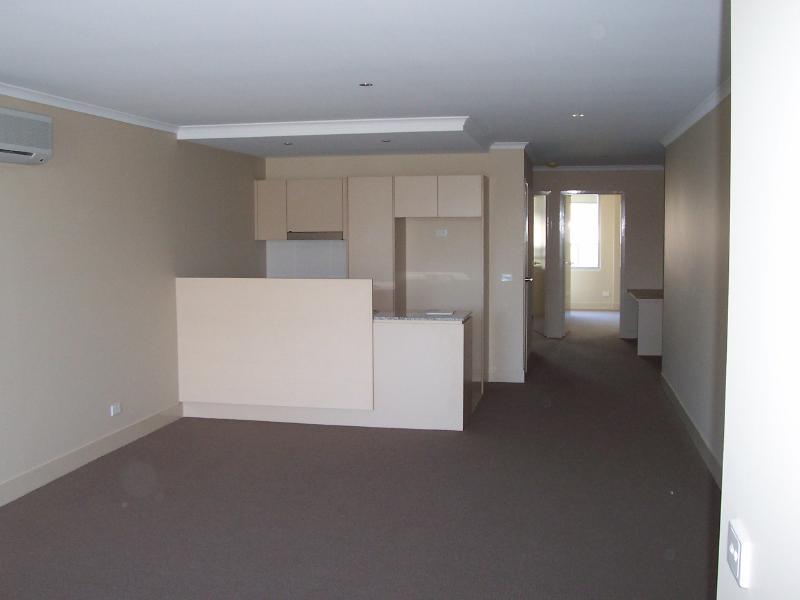 Living Room towards Kitchen, Media Centre near entry door and Bedrooms at back.