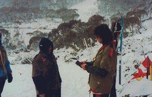 Two people facing each other in snowy conditions, performing a ceremony.